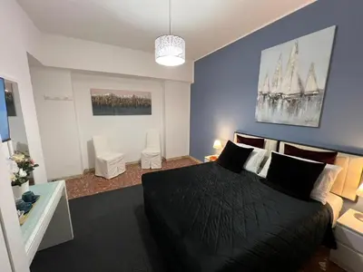 a bedroom with a black bed and a blue wall at affittacamere appia nuova 639 in Rome
