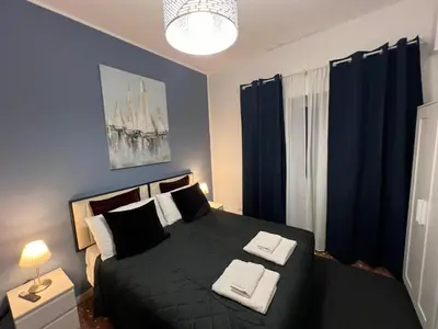 a bedroom with a black bed with blue curtains at affittacamere appia nuova 639 in Rome