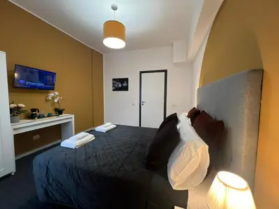 a bedroom with a bed in a room with a tv at affittacamere appia nuova 639 in Rome