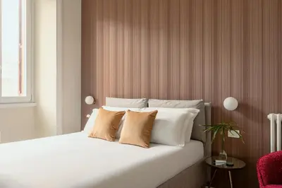 a white bed with two pillows on top of it at SJR Luxury Apartment Trevi Fountain in Rome