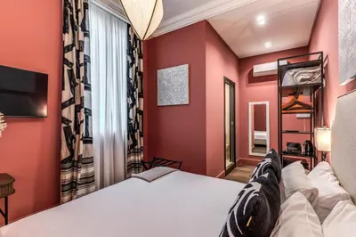 a bedroom with red walls and a bed and a window at Telier Belsiana in Rome