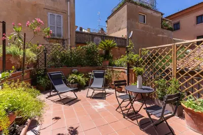a patio with chairs and a table in a courtyard at Telier Belsiana in Rome