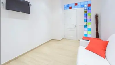 a living room with a white couch and a colorful wall at Vinyle Apartment Vatican in Rome