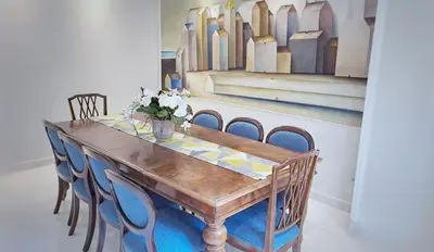 a dining room table with chairs and a painting at Vinyle Apartment Vatican in Rome