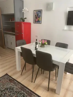 a white dining room table with chairs and a red refrigerator at Colosseo studios in Rome