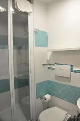 a bathroom with a toilet and a glass shower at Colosseo studios in Rome