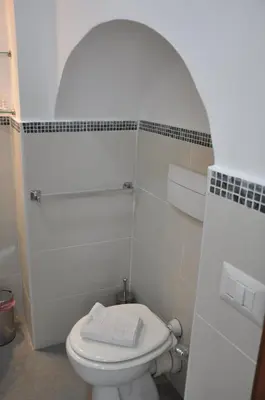 a white bathroom with a toilet and a sink at Colosseo studios in Rome