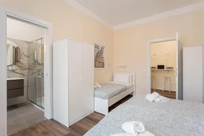 a bedroom with two beds and a mirror at Prati Grabau Comfort 3 rooms apt in Rome