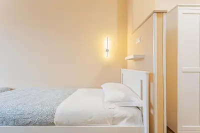 a white bedroom with a bed and a staircase at Prati Grabau Comfort 3 rooms apt in Rome