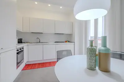a white kitchen with a vase on a table at D'Aquino Apartment St. Peter's in Rome