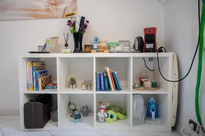 a white book shelf with toys and books at Cerroni's Corner in Rome