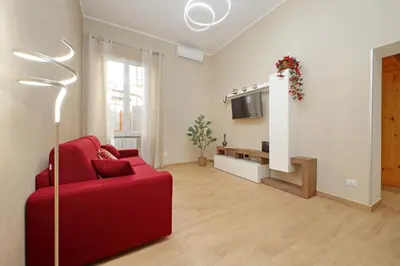 a living room with a red couch and a tv at Julius House in Rome