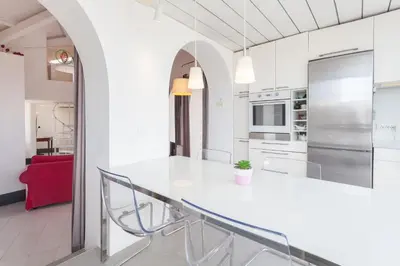 a white kitchen with a large white counter top at Prati Belfiore Guesthouse in Rome