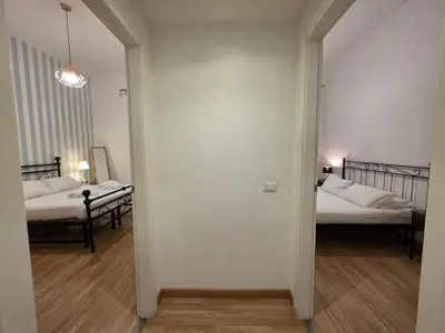 a hallway leading to two beds in a room with white walls at Be Your Home - MR House in Rome