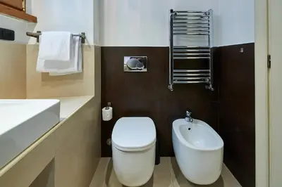 a bathroom with a white toilet and a sink at Central Suite Navona Campo de Fiori IREX Apartment in Rome