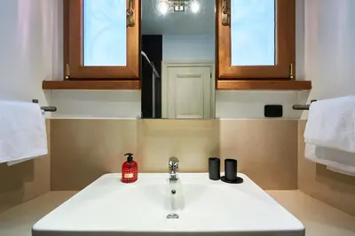 a bathroom with a white sink and a mirror at Central Suite Navona Campo de Fiori IREX Apartment in Rome