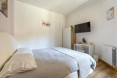 a white bedroom with a bed and a flat screen tv at Casa Camilla al Vaticano in Rome