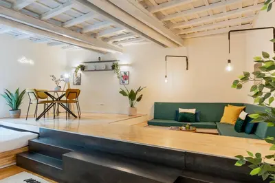 a living room with a green couch and a table at Cantoni 4A - Loft at Colosseum in Rome