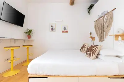 a white bedroom with a bed and a flat screen tv at Cantoni 4B - Studio at Colosseum in Rome