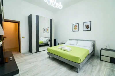 a bedroom with a green bed and a mirror at Casa Angelina - Appartamento zona SanGiovanni in Rome
