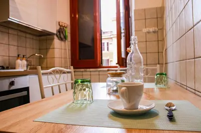 a table with a cup and a glass bottle on it at Casa Angelina - Appartamento zona SanGiovanni in Rome