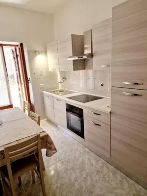 a kitchen with white cabinets and a table and a table sidx sidx sidx at Appartamento-Castro Pretorio in Rome