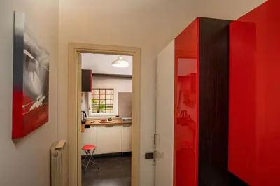 a hallway with a red door and a kitchen at Maison Medusa in Rome