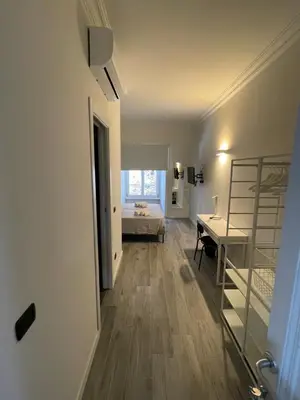 a hallway with a room with a bed and a desk at This must be the place Rome Guesthouse in Rome
