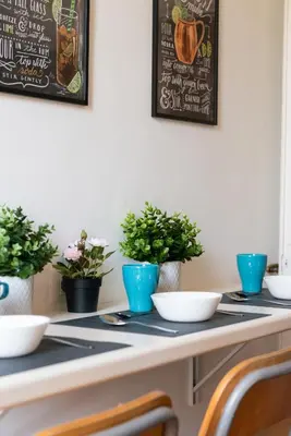 a table with bowls and potted plants on it at Piacentino Homes San Giovanni apartment in Rome