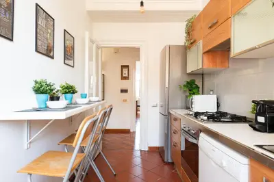a kitchen with white counters and wooden cabinets at Piacentino Homes San Giovanni apartment in Rome