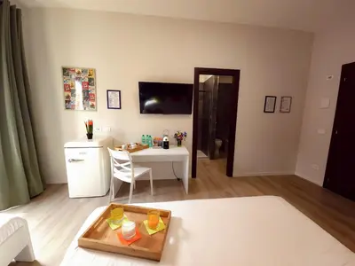 a living room with a white table and a kitchen at Piol Guest House in Rome