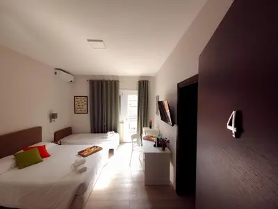 a hotel room with two beds and a table at Piol Guest House in Rome