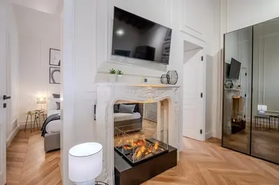 a living room with a fireplace with a tv above it at Acque Romane Piazza di Spagna in Rome