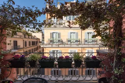 a building with potted plants on a balcony at Acque Romane Piazza di Spagna in Rome