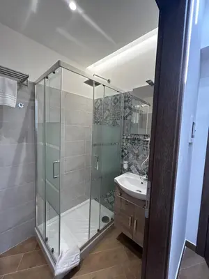 a bathroom with a glass shower and a sink at Grimaldi Comfort Guest House in Rome