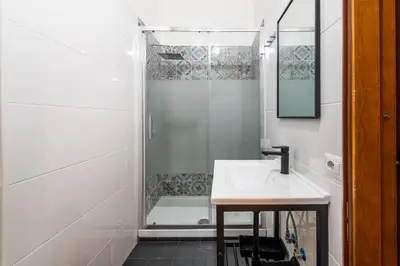 a white bathroom with a shower and a sink at Gianicolense Apartment in Rome
