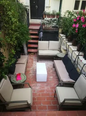 a patio with white couches and tables and flowers at Piazza Navona historical palace in Rome