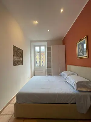 a bedroom with a large bed with orange walls at Steph and Lorenzo's place in Rome
