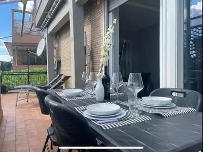 a black table with plates and glasses on a patio at La Terrazza di Vigna Clara in Rome