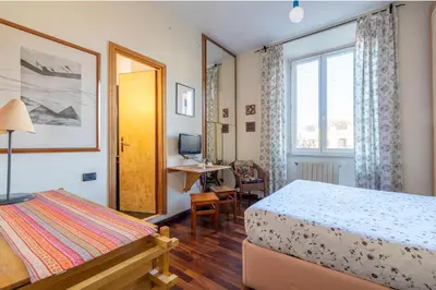 a bedroom with a bed and a desk and a window at New Trastevere Home: big, elegant, comfy apartment in Rome