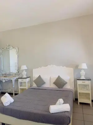 a bedroom with a bed with two tables and a mirror at Blancmaisonteveresuite in Rome