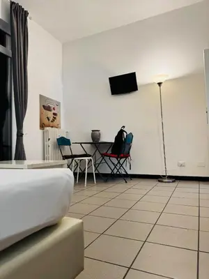 a white room with a table and a tv on the wall at Blancmaisonteveresuite in Rome
