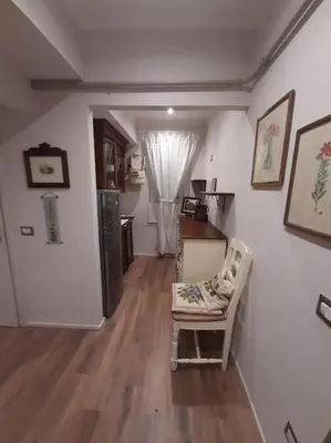 a living room with a chair and a kitchen at Appartamento Suite Ponte Milvio in Rome