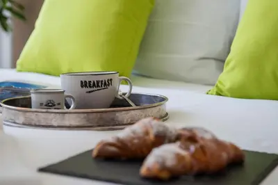 a tray with a coffee cup and a pastry on a bed at New special vrbs Roma apartament in Rome
