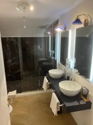 a bathroom with two sinks and a shower at Rome luxury blue suites- IMPERIAL in Rome