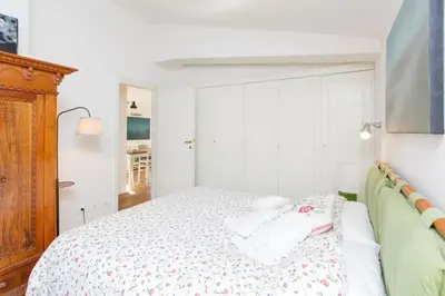 a white bedroom with a bed with a wooden headboard at Sales in Rome