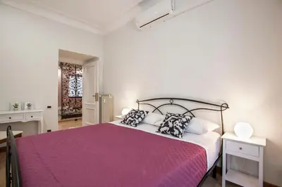 a bedroom with a large bed with a purple blanket at Appia Luxe - A poche fermate del Centro in Rome