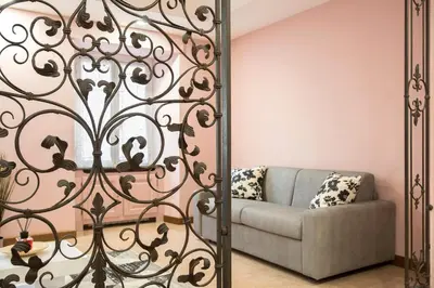 a living room with a couch and a mirror at Appia Luxe - A poche fermate del Centro in Rome