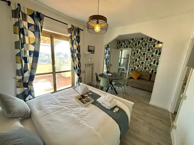 a bedroom with a large bed and a living room at Attico al Settimo Piano in Rome