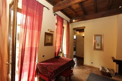 a room with red curtains and a table in a room at Bollo Studio in Rome